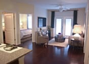 Thumbnail 5 of 65 - A living room with a couch, chair, and a table with a lamp on it.