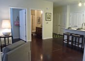 Thumbnail 4 of 65 - A living room with a grey couch and a lamp on a table.