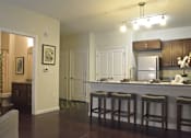 Thumbnail 9 of 65 - A kitchen with a bar area and a refrigerator.