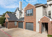 Thumbnail 22 of 24 - A house with a brick facade and a garage door.