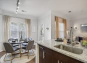 Thumbnail 7 of 47 - a kitchen with a sink and a table with chairs