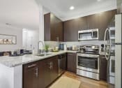 Thumbnail 5 of 47 - a modern kitchen with stainless steel appliances and marble counter tops