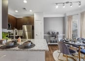 Thumbnail 4 of 47 - a kitchen and dining area with stainless steel appliances and a granite counter top