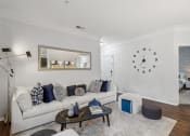 Thumbnail 3 of 47 - a living room with a white couch and a clock on the wall