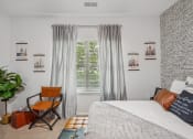Thumbnail 18 of 47 - a bedroom with a bed and a window with curtains and a chair
