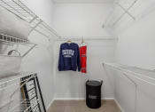 Thumbnail 21 of 47 - a walk in closet with white walls and white racks and a laundry room with clothes