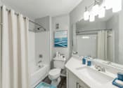 Thumbnail 7 of 22 - A bathroom with a toilet, sink, and shower.