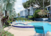 Thumbnail 21 of 22 - A pool surrounded by trees and chairs.