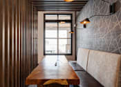 Thumbnail 20 of 47 - A long wooden table with a couch and a window in the background.