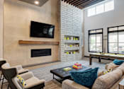 Thumbnail 19 of 47 - A modern living room with a fireplace and a television.