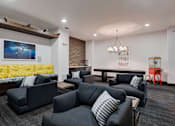Thumbnail 27 of 47 - A modern living room with grey couches and a yellow sofa.