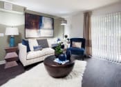 Thumbnail 14 of 25 - Ardenne Apartments model apartments with a white couch, blue chair and hardwood-style floor