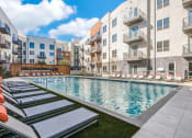 Thumbnail 3 of 37 - Sparkling resort style swimming pool with cushioned lounge chairs