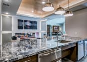 Thumbnail 6 of 37 - Granite counter tops, stainless appliance package, medium brown cabinets, plank wood-style flooring, island seating, abundant cabinet and pantry space