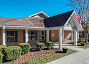 Thumbnail 9 of 26 - the front of a brick house with an flag in the front yard
