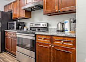 Thumbnail 1 of 26 - a kitchen with stainless steel appliances and wooden cabinets