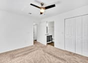 Thumbnail 6 of 26 - A room with a ceiling fan and carpeted floor.