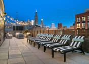 Thumbnail 5 of 31 - a row of lounge chairs on a rooftop terrace with a view of the city