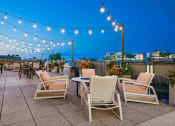Thumbnail 2 of 31 - a roof top patio with chairs and tables and lights