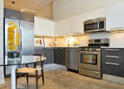 Thumbnail 17 of 31 - a kitchen with stainless steel appliances and a glass table