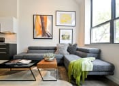 Thumbnail 20 of 31 - a living room with a gray couch and a coffee table