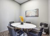 Thumbnail 16 of 31 - a dining room with a table and chairs and a painting on the wall