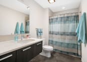 Thumbnail 29 of 31 - a bathroom with a shower and a sink and a toilet