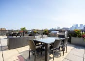 Thumbnail 7 of 31 - a rooftop terrace with a table and chairs and a city in the background
