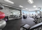 Thumbnail 12 of 31 - a gym with cardio equipment and windows in a building