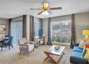Thumbnail 43 of 77 - a living room with a couch and a table and a ceiling fan