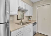Thumbnail 69 of 77 - a kitchen with white cabinets and a stainless steel refrigerator