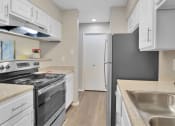 Thumbnail 49 of 77 - a renovated kitchen with white cabinets and stainless steel appliances