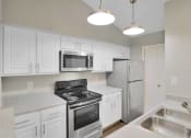 Thumbnail 58 of 77 - a kitchen with stainless steel appliances and white cabinets