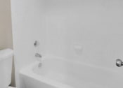 Thumbnail 65 of 77 - a white bathroom with a tub and a toilet
