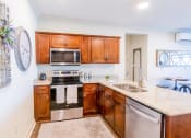 Thumbnail 13 of 19 - a kitchen with wooden cabinets and stainless steel appliances