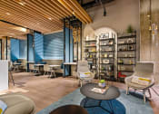 Thumbnail 8 of 31 - a lobby with chairs and tables and a bookshelf
