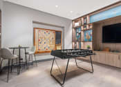 Thumbnail 28 of 31 - a game room with a foosball table and a television
