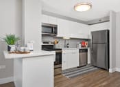 Thumbnail 4 of 31 - a white kitchen with stainless steel appliances and a counter top