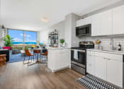 Thumbnail 3 of 31 - an open kitchen and living room with a view of the ocean