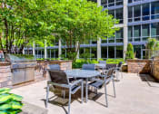 Thumbnail 2 of 28 - a patio with a table and chairs in front of a building