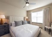 Thumbnail 14 of 39 - a bedroom with a white bed and a ceiling fan