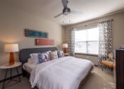 Thumbnail 18 of 39 - a bedroom with a bed and a ceiling fan