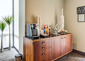 Thumbnail 4 of 34 - A wooden cabinet with a TV on top and a plant to the left.