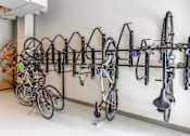 Thumbnail 24 of 34 - A wall-mounted bike rack with several bicycles and a scooter.