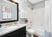 Thumbnail 34 of 34 - A bathroom with a white toilet, a sink, and a shower.