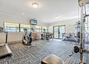 Thumbnail 13 of 22 - A gym with a variety of equipment including treadmills, weights, and exercise machines.