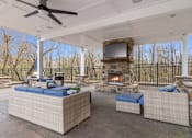 Thumbnail 16 of 30 - A patio with a fireplace and seating area.