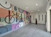 Thumbnail 24 of 30 - A hallway with a mural of various shapes and symbols.