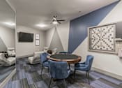 Thumbnail 6 of 30 - A room with a round table and chairs, a ceiling fan, and a television.