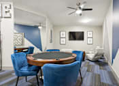 Thumbnail 8 of 30 - A conference room with a round table and blue chairs.